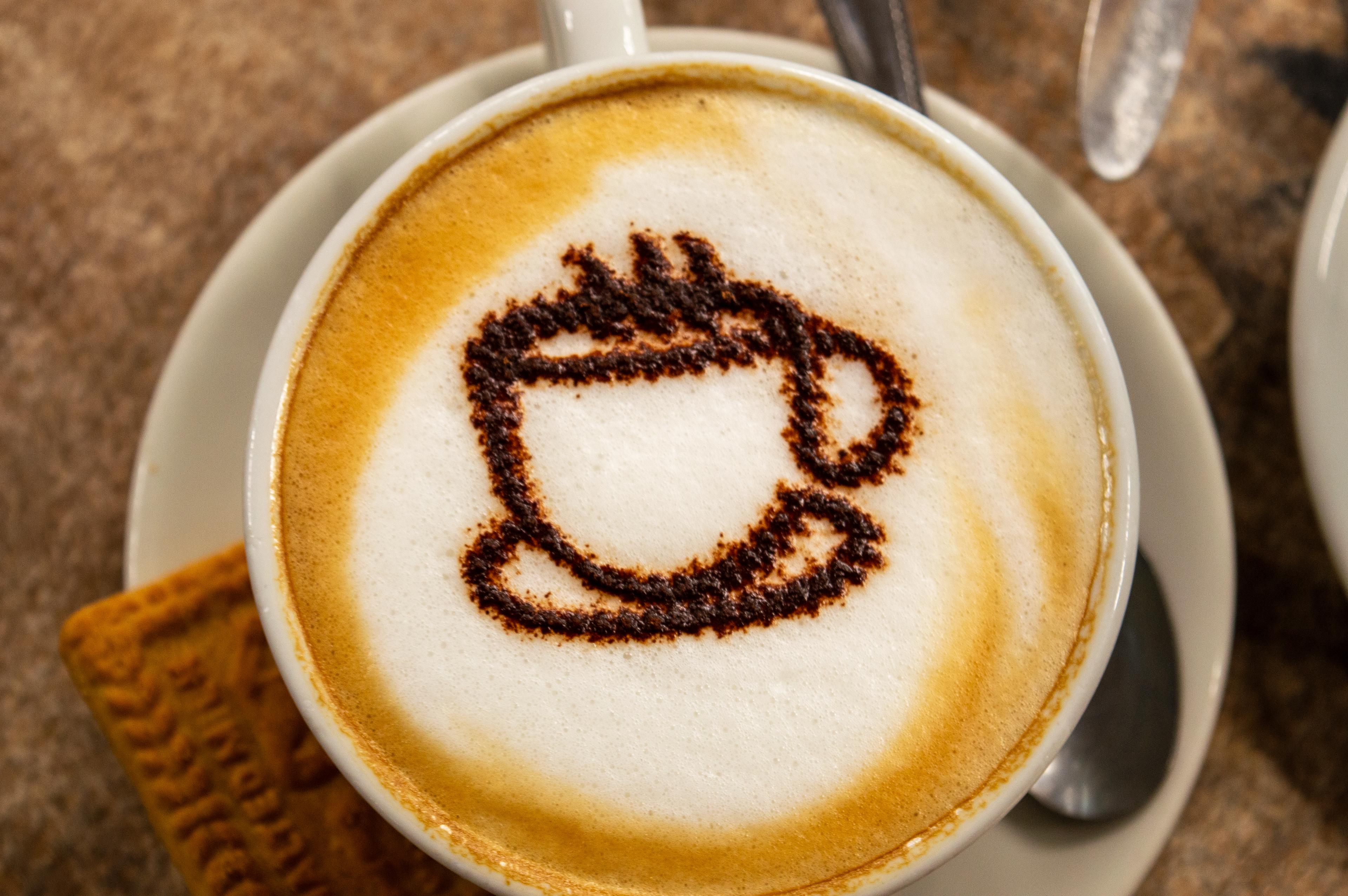 A delicious range foamy latte with a biscuit